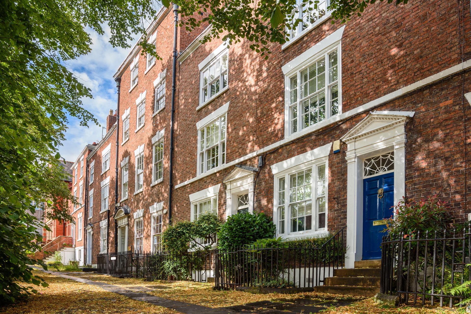 Row of traditional red brick townhouses on a sunny summer day